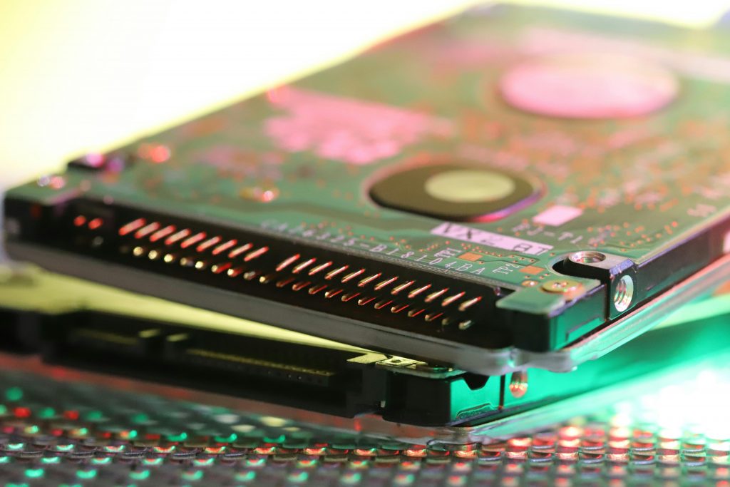 Detailed view of a computer hard disk circuit board with colorful reflections.